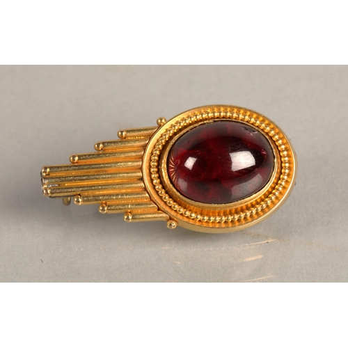 103 - Yellow metal brooch set with a ruby coloured cabochon gem, 4g