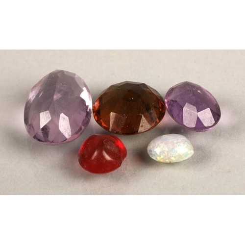 70 - Five loose gems, two purple amethyst coloured, one smoky brown coloured, a red, and an imitation opa... 