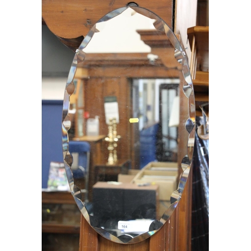 164 - Frameless bevel edge wall mirror of oval form, 66cm x 38cm.