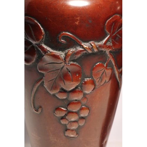 251 - Pair of Japanese bronze baluster vases decorated with relief fruiting vines, 21cm high.