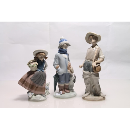 255 - Three Lladro figurines to include boy with dog, boy with fishing basket and girl with flowers, large... 