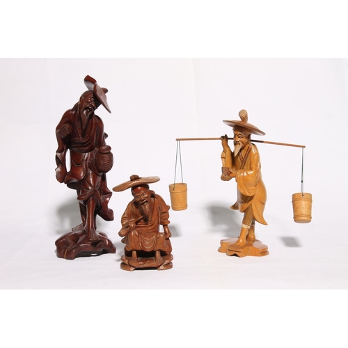 37 - Three Chinese carved wooden figures, largest 26cm high.