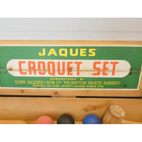 106 - Jaques croquet set, comprising of four clubs, four balls, six hoops, end post etc. In a stenciled pi... 