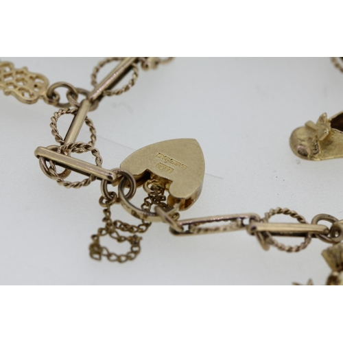 464 - 9ct gold charm bracelet with heart shaped clasp and holding six individually hallmarked 9ct gold cha... 