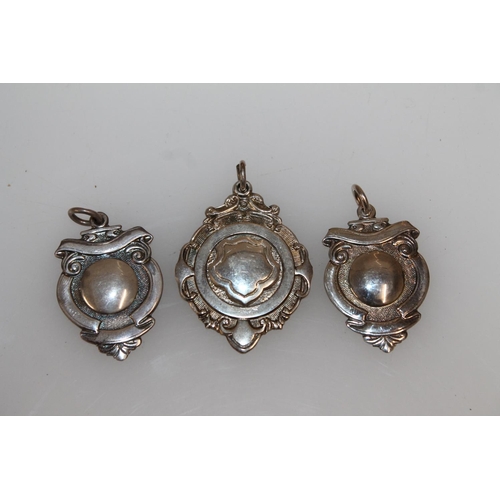 473 - Pair of hallmarked silver plain sporting fobs, and a white metal fob engraved Andrews Cup Rnrs-Up 57... 