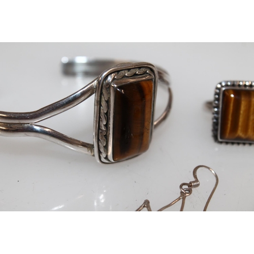 626 - Suite of white metal and tigers eye jewellery comprising bracelet, ring and pair of earrings.