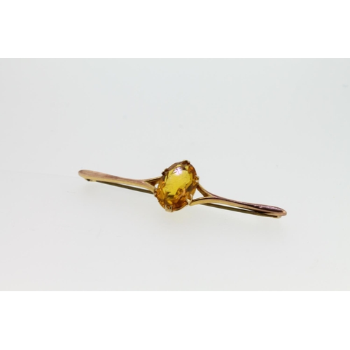 545 - Yellow metal bar brooch set with oval citrine, tests as 9ct, 4.1g.