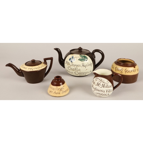 27 - Two Cumnock motto ware teapots, a milk jug and a storage jar (4)