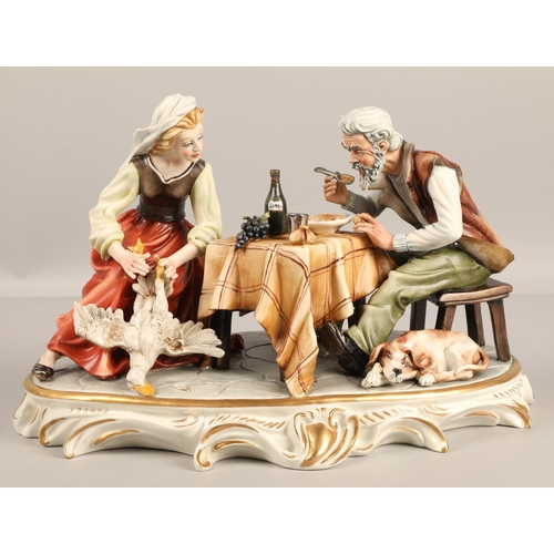 358 - Capodimonte  figure depicting two figures at a table on oval base.