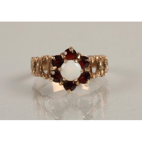 221 - 9ct gold ring set with milky opal surrounded by six garnet coloured gems, gross weight 3.2g, ring si... 