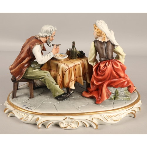 358 - Capodimonte  figure depicting two figures at a table on oval base.