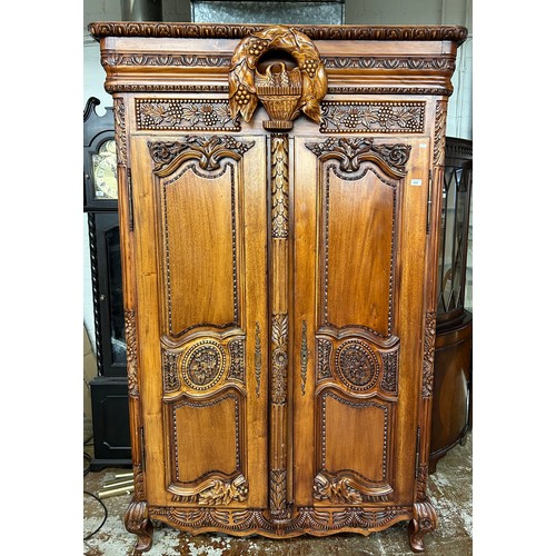 600 - Carved armoire with intricate floral, leaf and bird designs, raised on cabriole legs. H 212cm, W 124... 