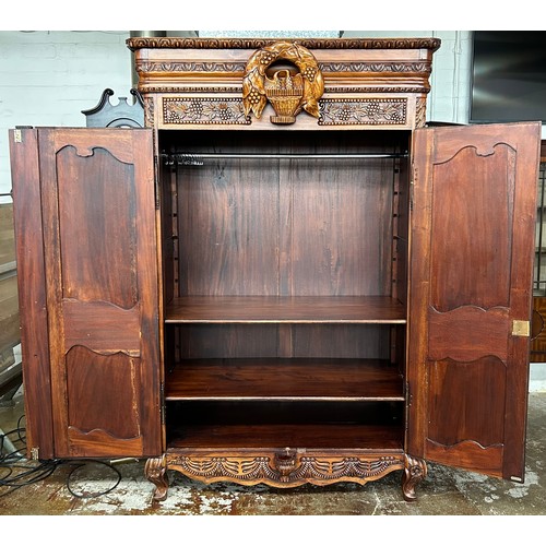 600 - Carved armoire with intricate floral, leaf and bird designs, raised on cabriole legs. H 212cm, W 124... 