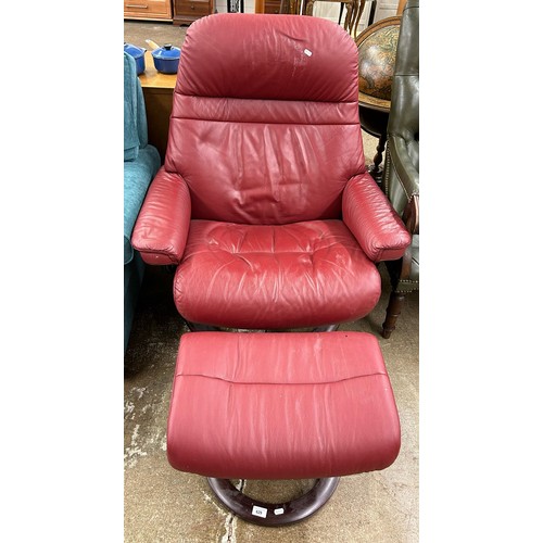 629 - Red leather swivel armchair with matching foot stool