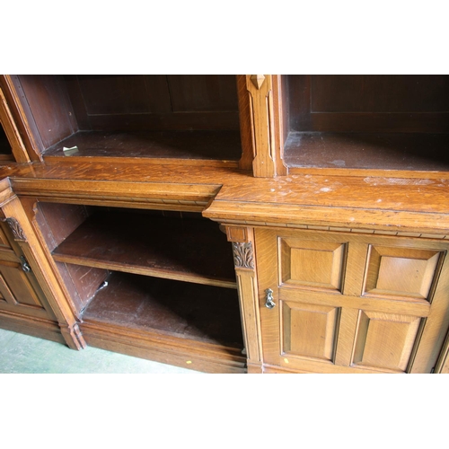 450 - Victorian oak break front bookcase with two cabinets to lower section, 241cm tall x 226cm wide.