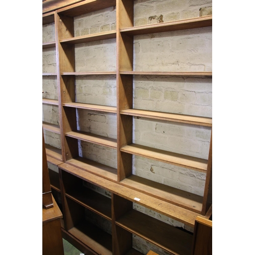 473 - Large four section oak open bookcase on plinth base, 260cm wide.