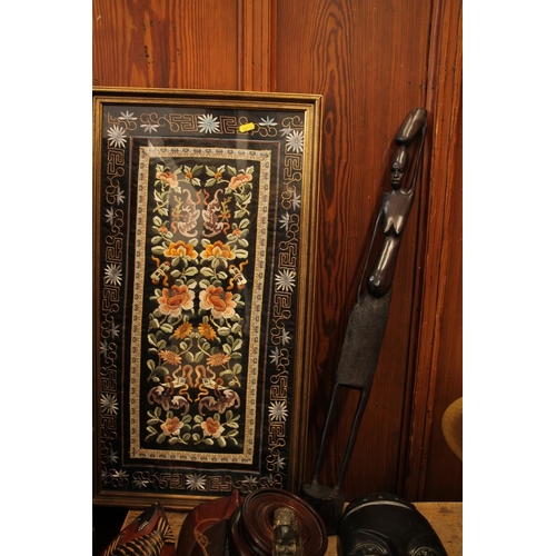 112 - African wooden masks and other tribal items along with an oriental embroidered panel.