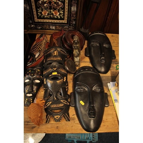 112 - African wooden masks and other tribal items along with an oriental embroidered panel.