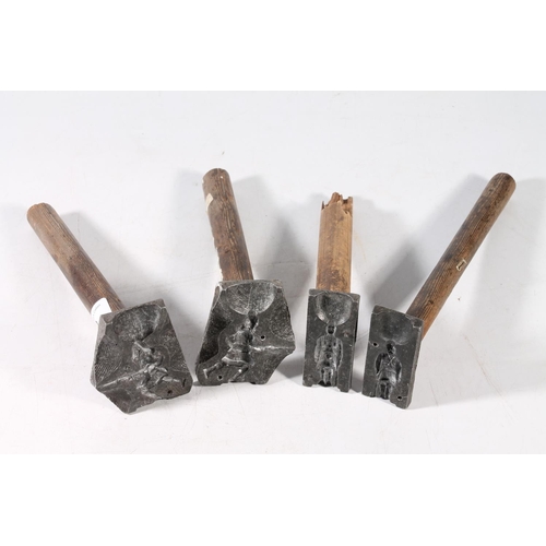 69 - Cast metal moulds on wooden handles, the moulds in the form of Scottish soldiers.