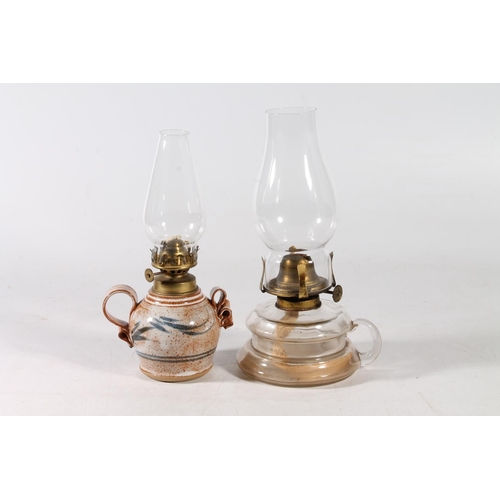74 - Studio Pottery oil lamp with glass chimney, and an all glass oil lamp with chimney, largest 26cm hig... 