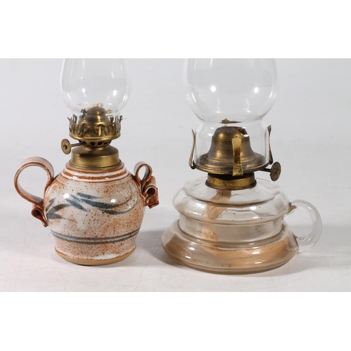 74 - Studio Pottery oil lamp with glass chimney, and an all glass oil lamp with chimney, largest 26cm hig... 
