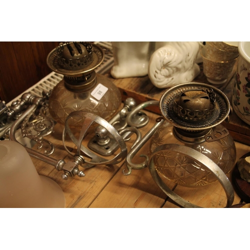 98 - Pair of chromed decorative oil lamp sconces and fitted glass oil lamp reservoirs.