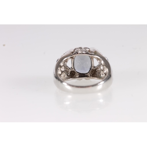 104 - 18ct white gold and blue stone modernist ring, the central cushion cut steel blue stone flanked by r... 