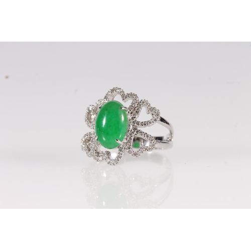 105 - 18ct white gold Jade and diamond ring, the oval cabochon jade stone flanked by a cluster of small ro... 