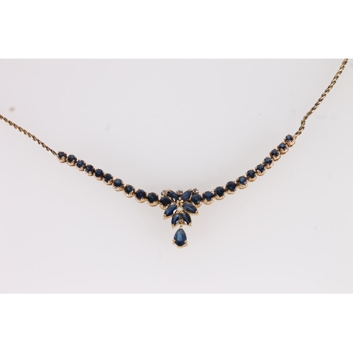 121 - 14ct gold and blue stone necklace, the pear shaped drop below a cluster of marquis cut stones, flank... 