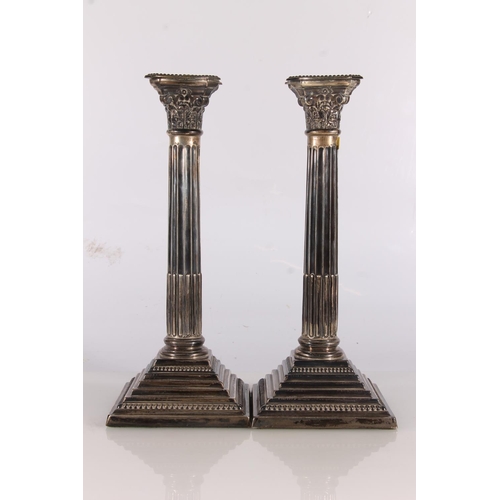 19 - Pair of Elizabeth II silver candlesticks of Corinthian column form raise on stepped square bases, by...