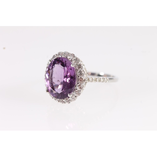 99 - 9ct white gold and amethyst ring, the oval cut amethyst within a halo of small diamonds, the under b... 