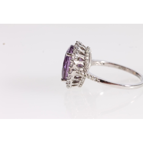 99 - 9ct white gold and amethyst ring, the oval cut amethyst within a halo of small diamonds, the under b... 