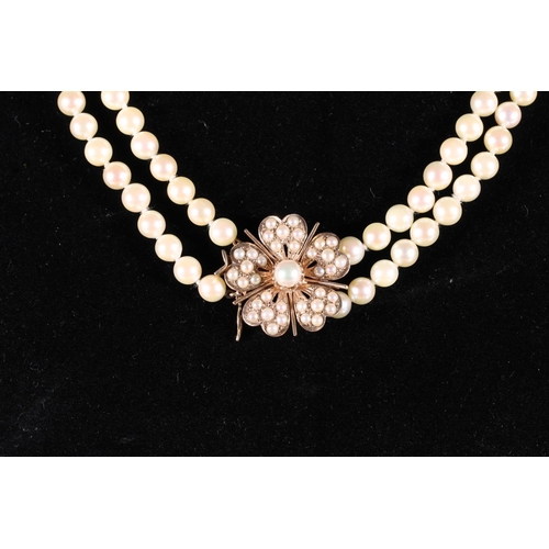 167 - Double strand pearl necklace with 9ct gold flower head shaped clasp set with pearls by MK Ltd.