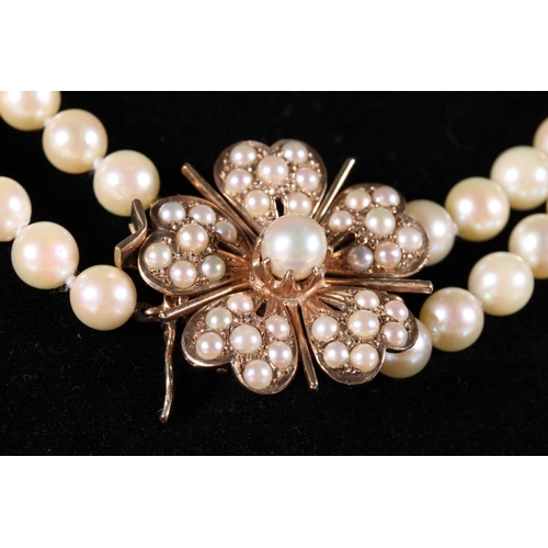 167 - Double strand pearl necklace with 9ct gold flower head shaped clasp set with pearls by MK Ltd.