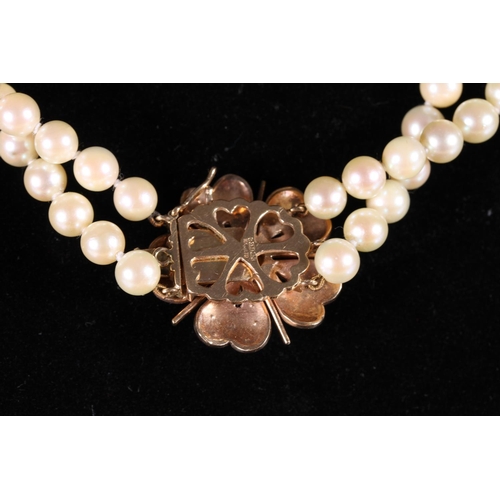 167 - Double strand pearl necklace with 9ct gold flower head shaped clasp set with pearls by MK Ltd.