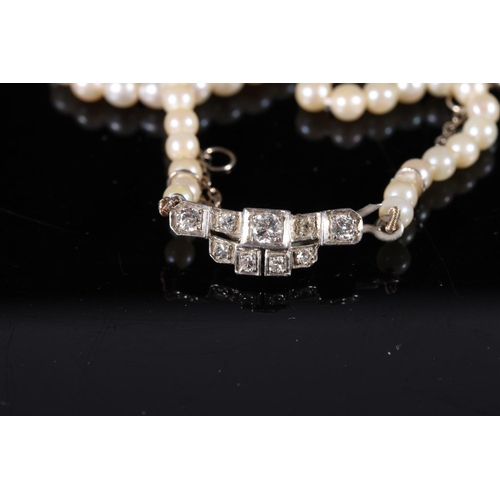 168 - Single strand pearl necklace with Art Deco style white metal closure set with diamonds, and a single... 