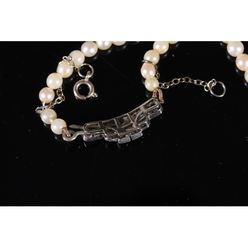 168 - Single strand pearl necklace with Art Deco style white metal closure set with diamonds, and a single... 