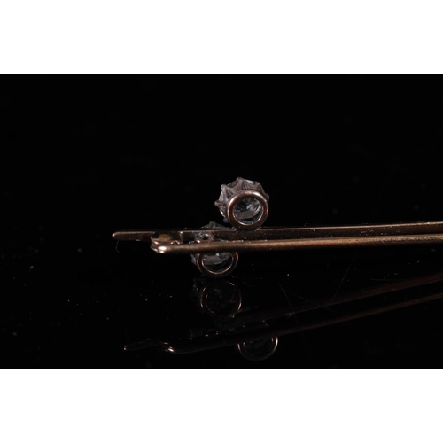 177 - Unmarked yellow metal bar brooch set with two round cut diamonds, each approx. 0.35 ct.