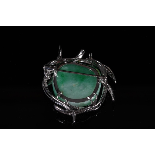 178 - Jade and diamond brooch, the irregular white green jade cabochon within a branched white metal mount... 