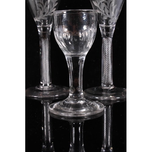 306 - Pair of George III wine glasses, c1770, the round funnel bowls engraved with wreaths on an air twist... 