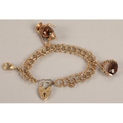 176 - 9ct gold charm bracelet with heart padlock and three gold charms (one gem set spinner fob, one with ... 