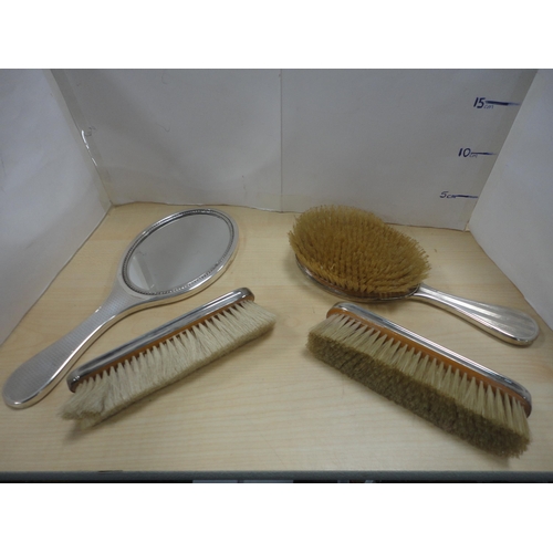 107 - Three-piece silver-backed engine-turned dressing table brush set, and another silver-backed engine-t... 