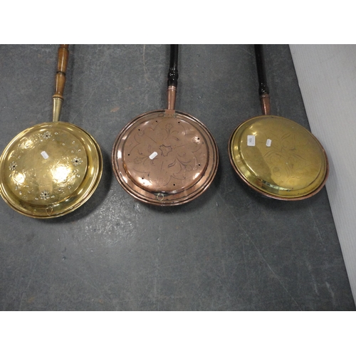 184 - Two brass-mounted bed warming pans and a copper bed warming pan.  (3)