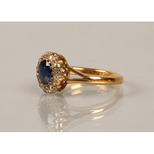 101 - 22ct gold ring set with a central blue gem surrounded by diamonds, ring size M, 5.2g