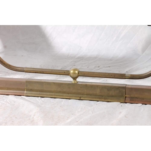 370 - 20thC brass and leather club fender, the burgundy seats on extendable brass shaped frame, max W159cm... 