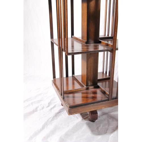 385 - Two Edwardian revolving bookcases with inlaid marquetry tops and slatted compartments, max H85cm.