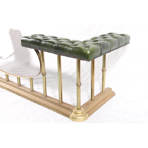 387 - 20thC brass and leather club fender, the green deep button seats on brass shaped frame, max W186cm.