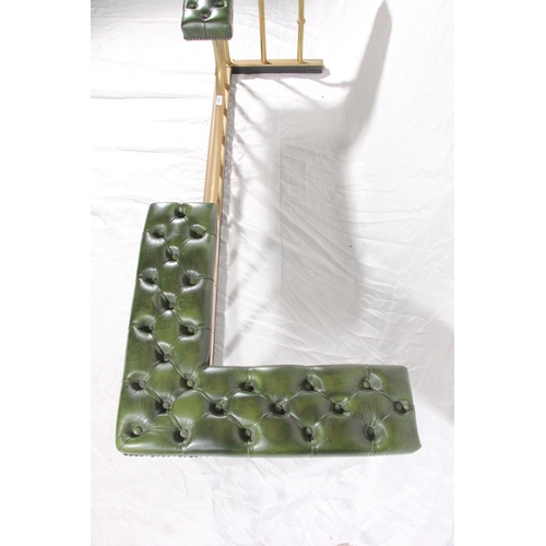 387 - 20thC brass and leather club fender, the green deep button seats on brass shaped frame, max W186cm.