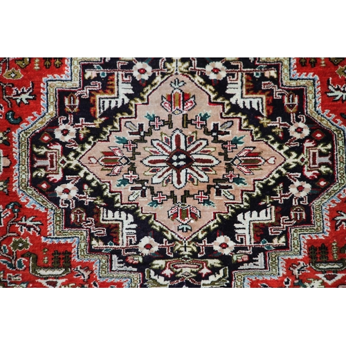 417 - Persian Kashan rug, with a central shaped medallion, within a red field of foliate designs and palme... 