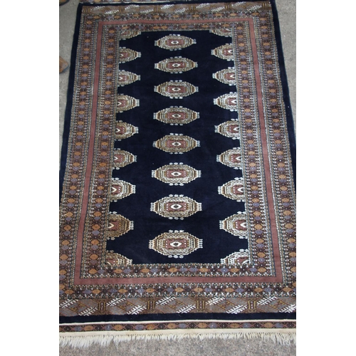 418 - Bokhara rug, the row of cream geometric guls on a blue field within geometric borders, 215cm x 130cm... 